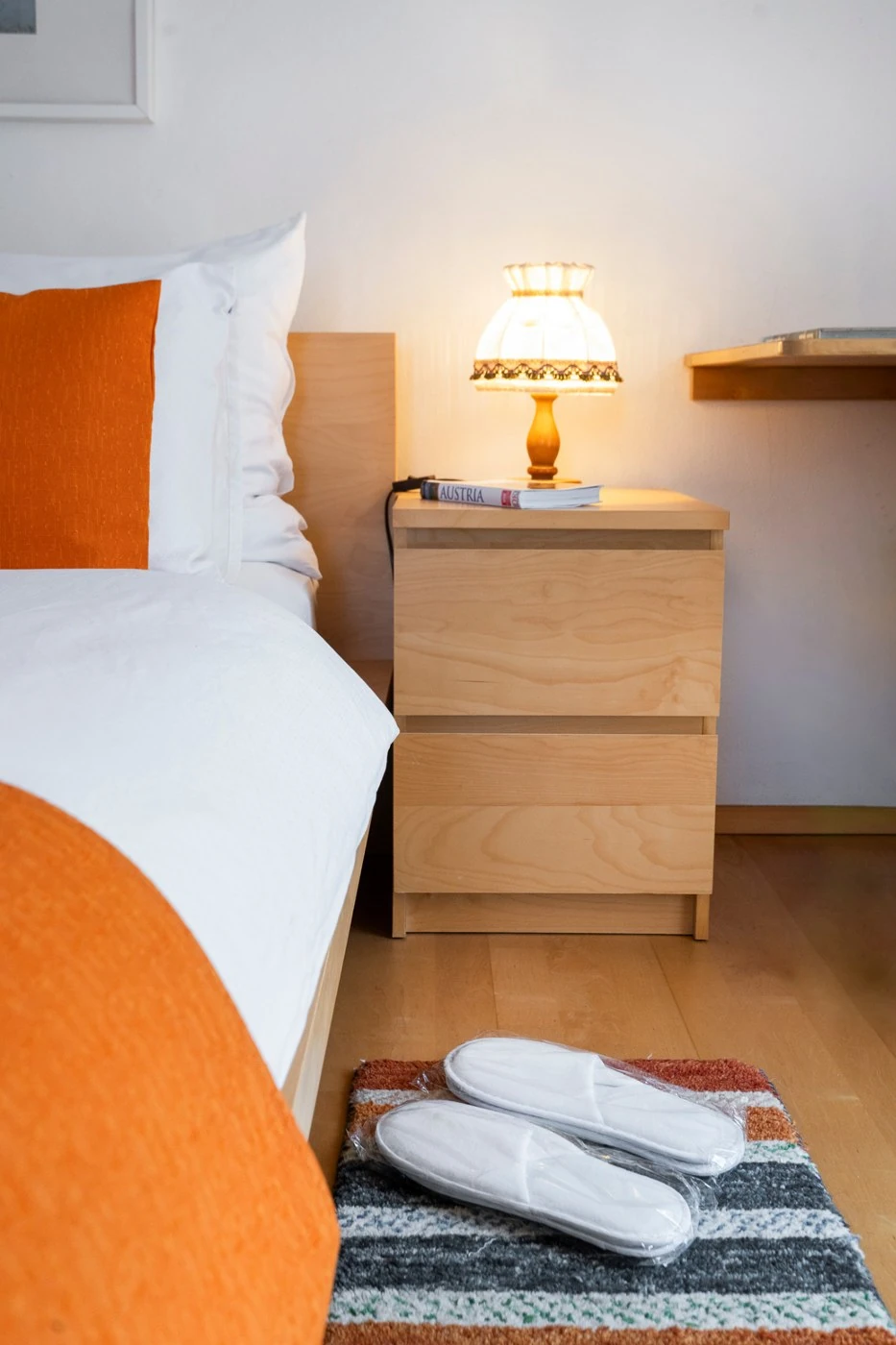 Nachttisch mit Lampe neben dem Doppelbett