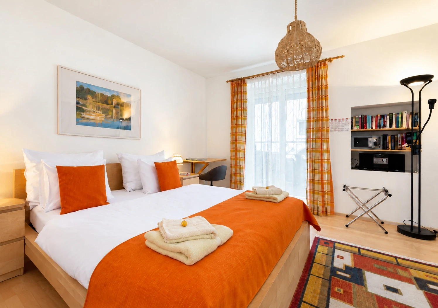 Schlafzimmer der Erdgeschosswohnung mit orangefarbener Tagesdecke