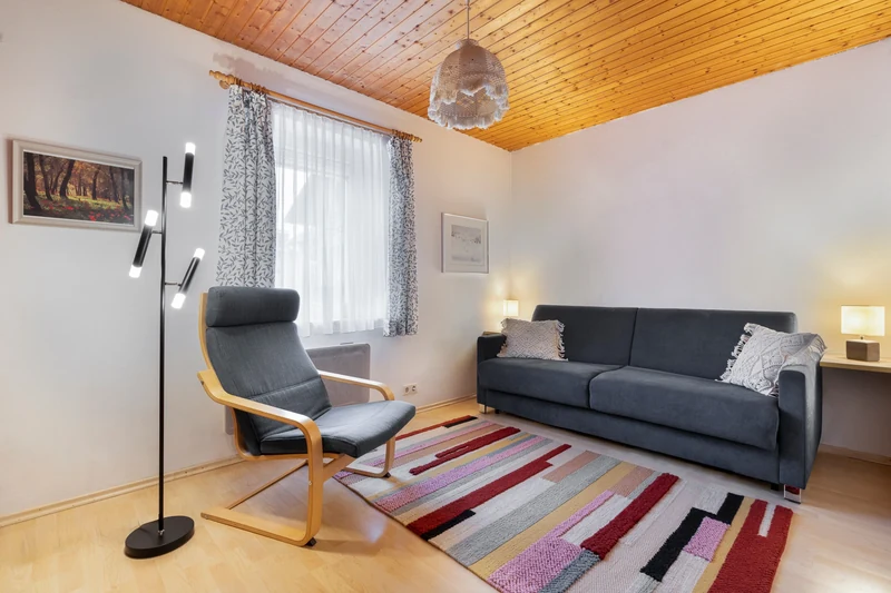 Wohnzimmer mit blauem Sofa und Lehnstuhl