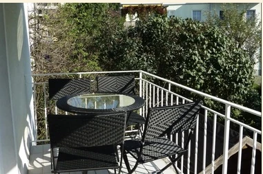 Balkon mit Tisch und Stühlen und Blick ins Grüne