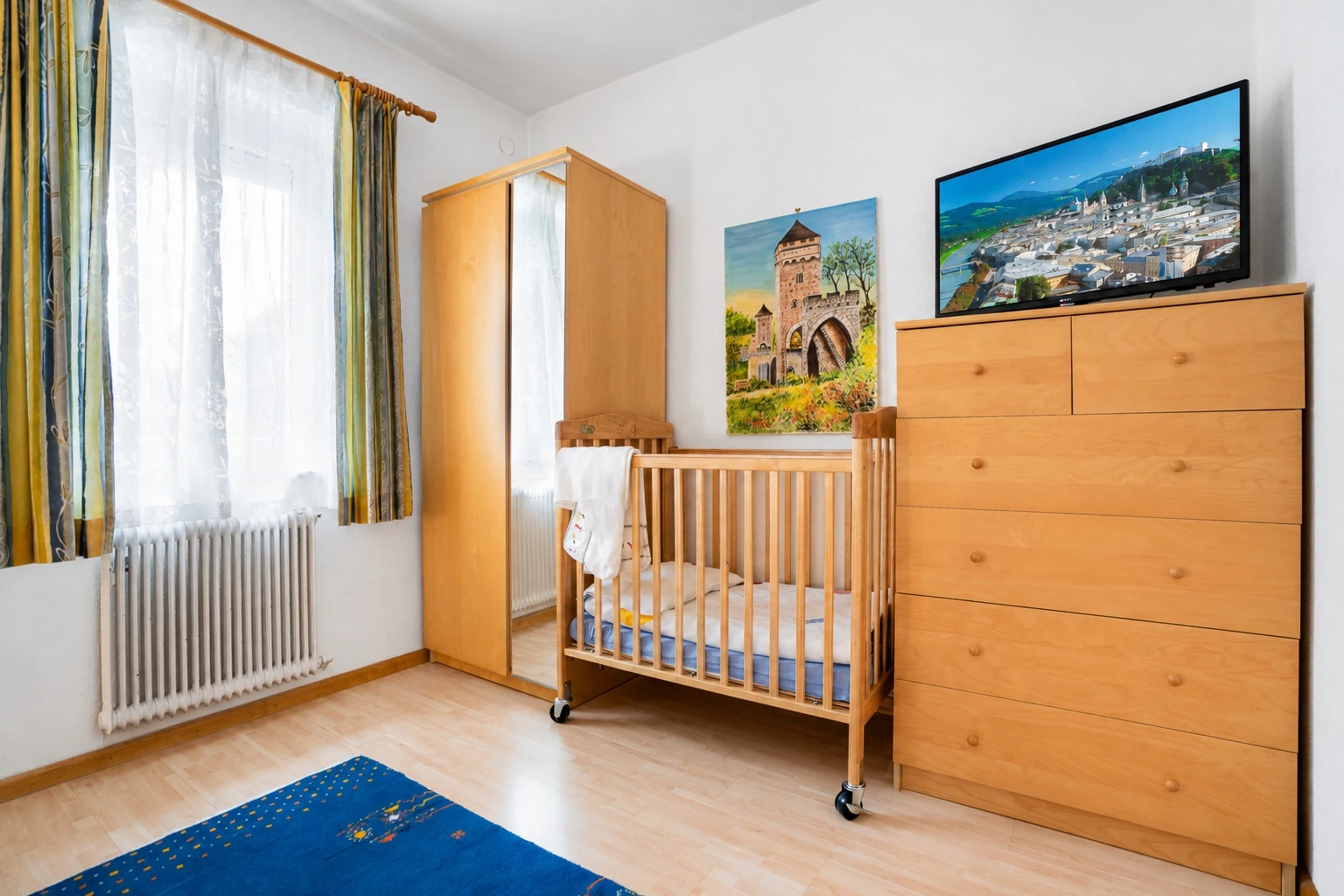 Erstes Schlafzimmer mit Babybett und Kommode