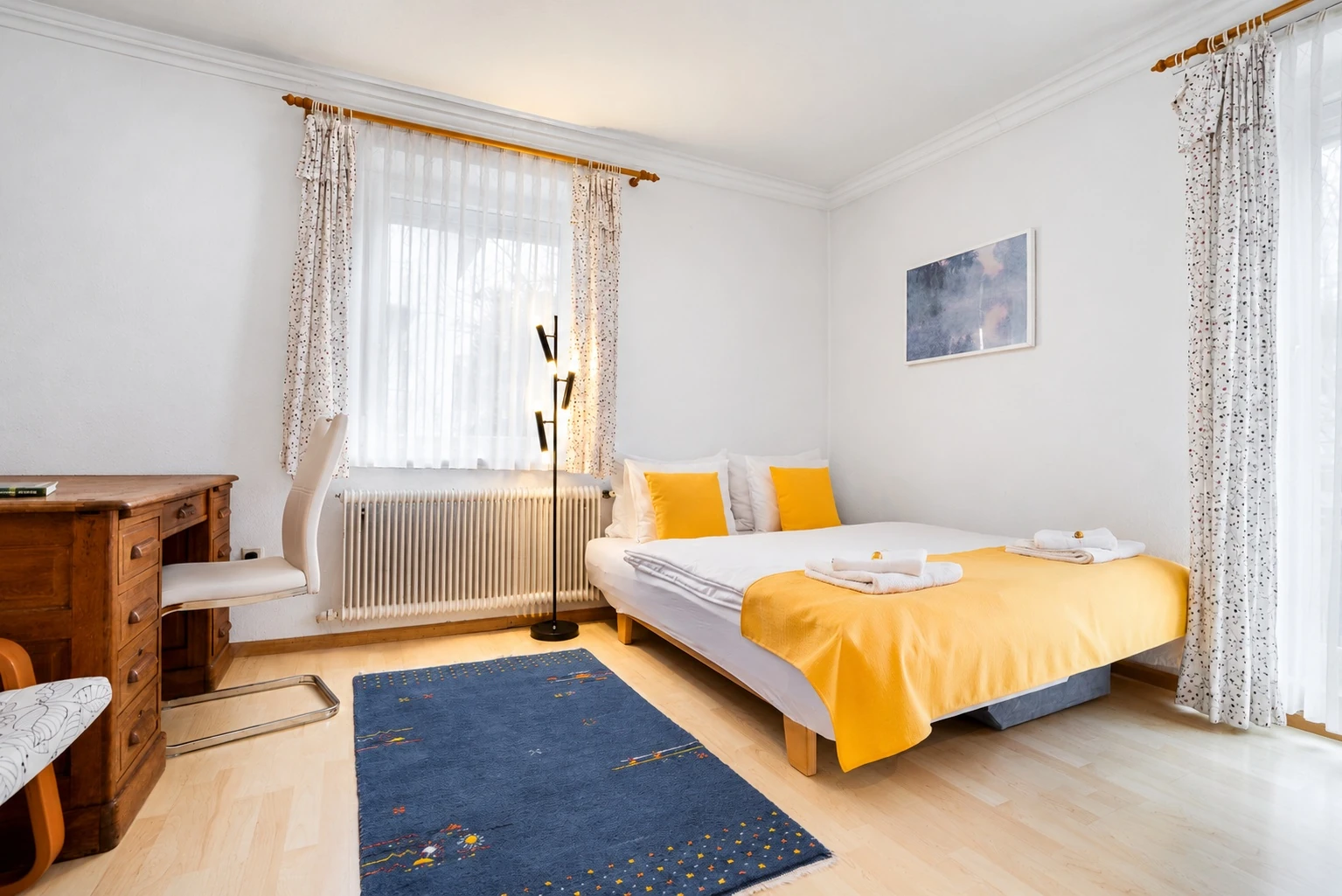Zweites Schlafzimmer mit Doppelbett und gelber Tagesdecke