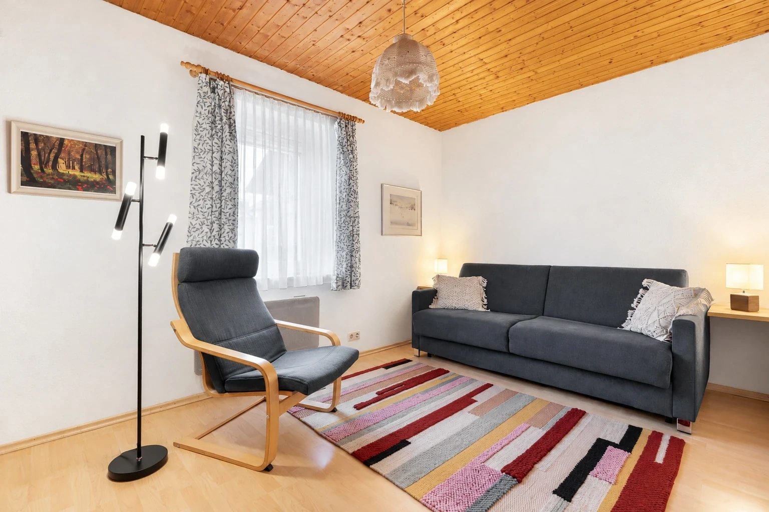 Wohnzimmer mit blauem Sofa und Lehnstuhl