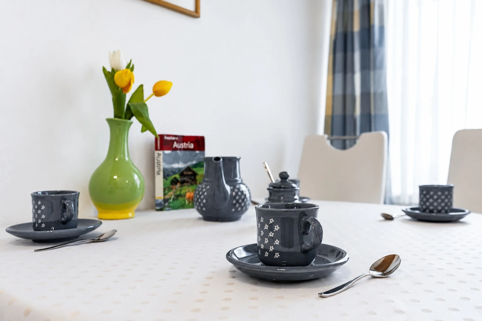 Esstisch mit Tassen und einer Vase mit Tulpen